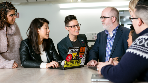 A startup team working together happily around a laptop